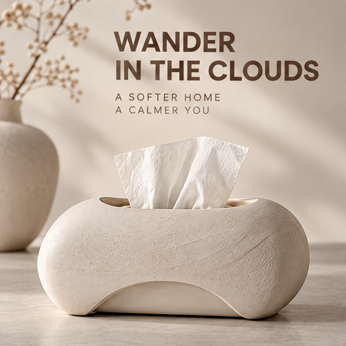 Cloud-inspired tissue box with a tissue protruding from the top beneath Wander in the Clouds.