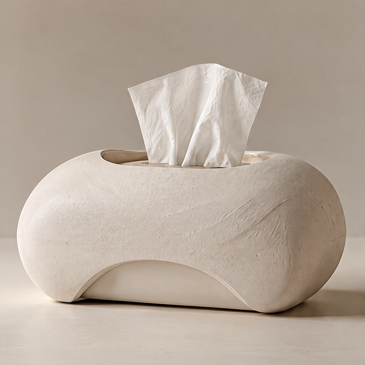 Off-white sculptural tissue box with a textured rounded body, oval top opening and curved lower arch on a plain background.